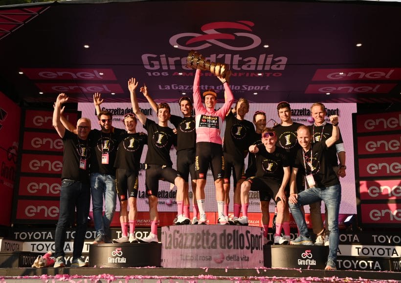 A team celebrates as they lift the Giro d'Italia trophy. Watch Giro d'Italia 2025 with Sportive Breaks