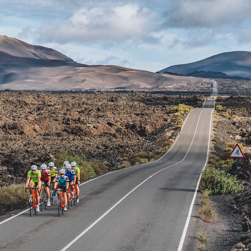 Cyclists passing over volcanic landscape in Tenerife