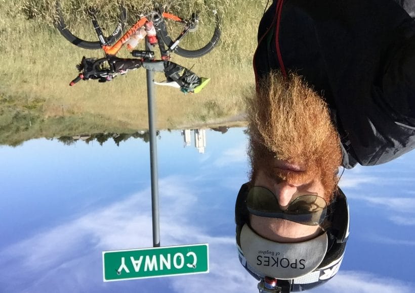 Ultra-endurance athlete Sean Conway poses in front of a sign for the town of Conway