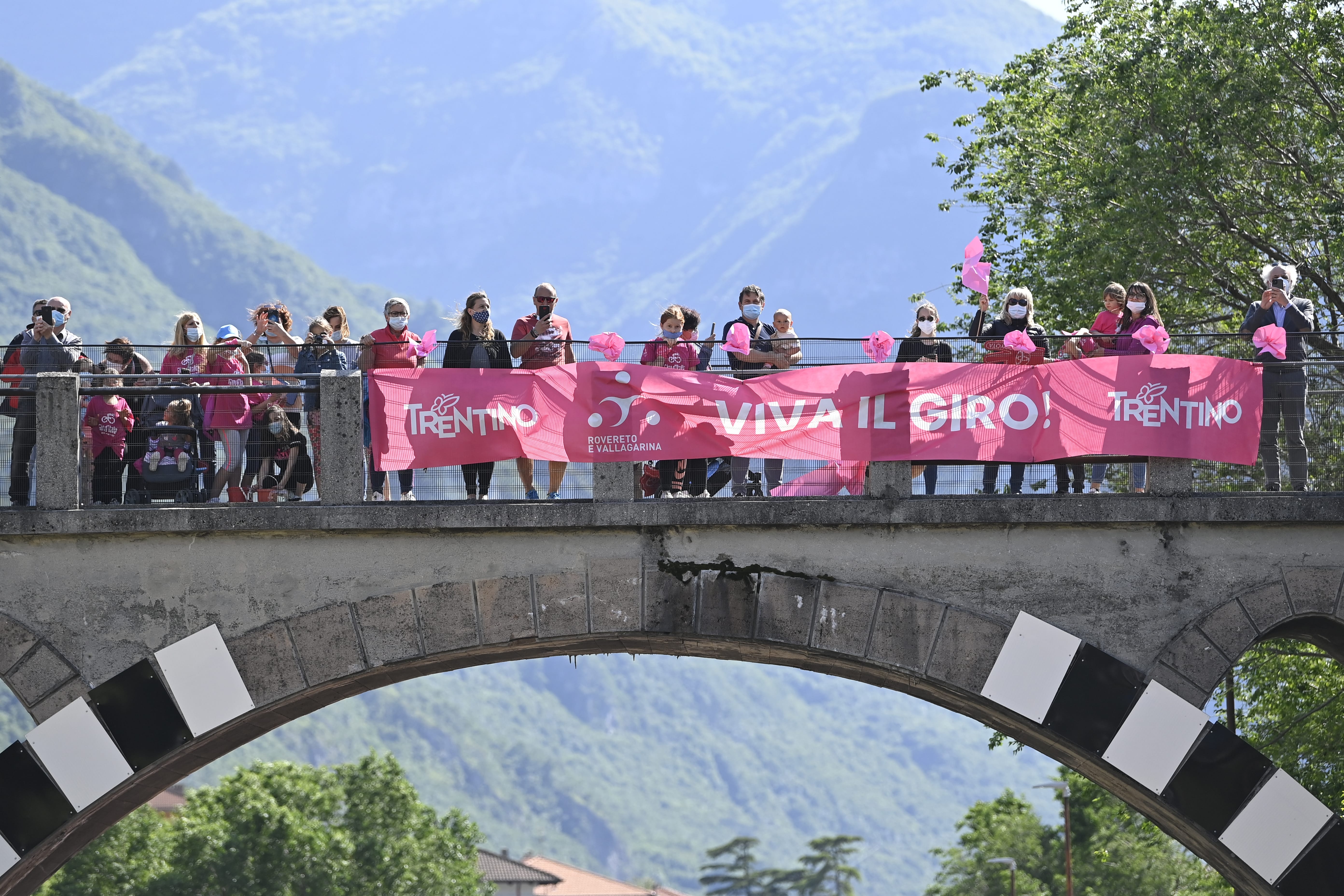 Riders wait on a bridge at the end of the Giro d'Italia 2025 route